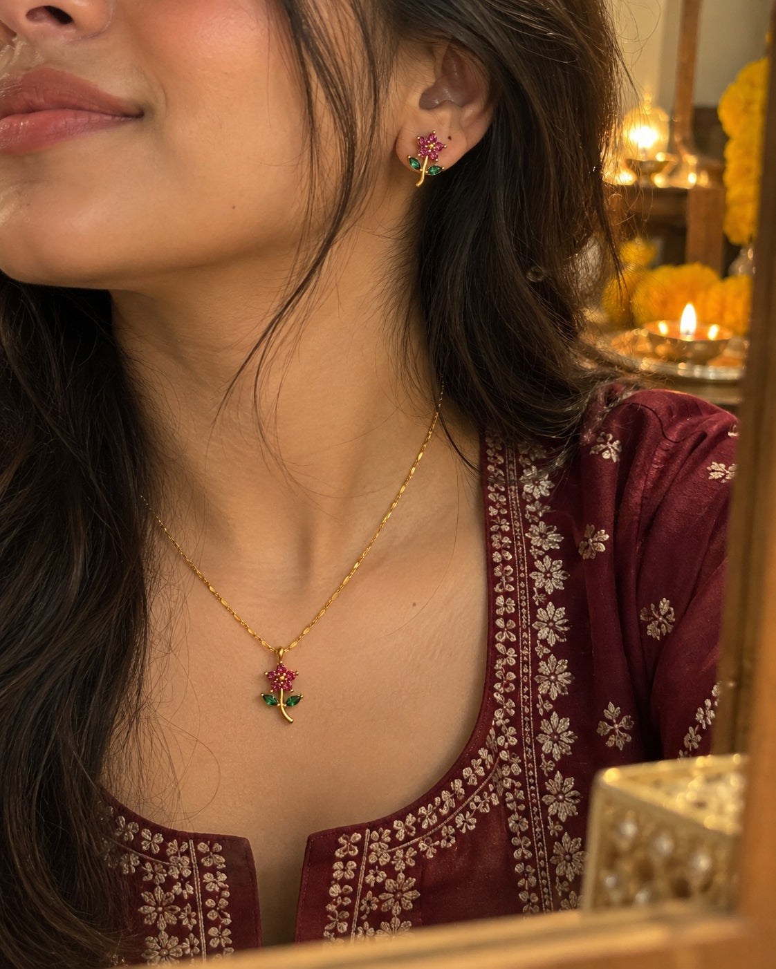 Ruby Rose Set worn with a maroon kurta, diyas behind her