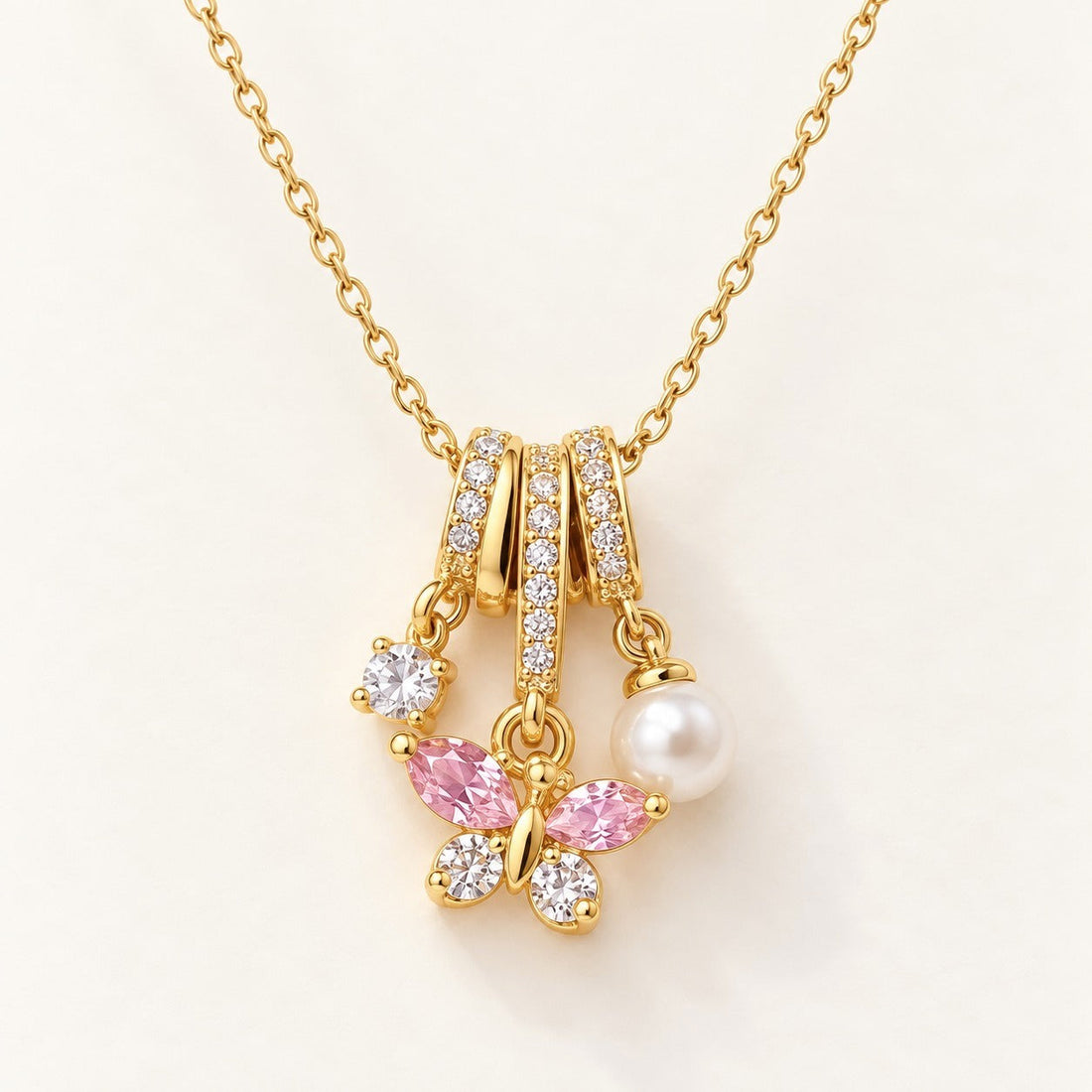 Butterfly Pearl Charm Necklace by NuNu: a crystal butterfly and a pearl drop on pavé rings, anti-tarnish gold tone