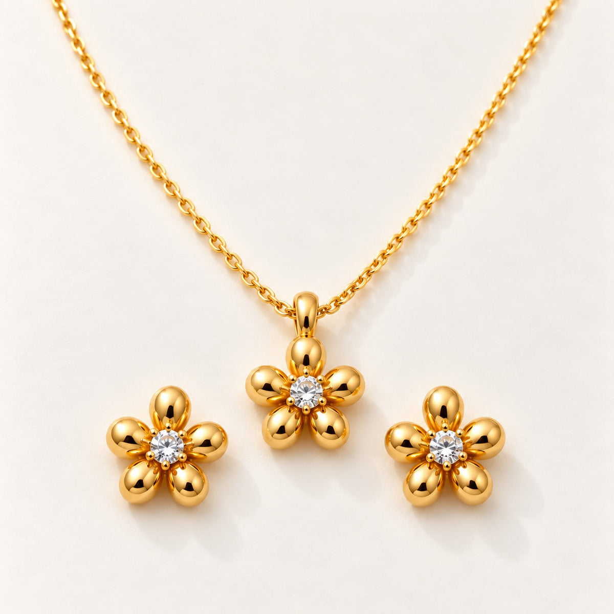 Gold Blossom Set by NuNu: a small gold flower pendant with matching studs, anti-tarnish gold tone