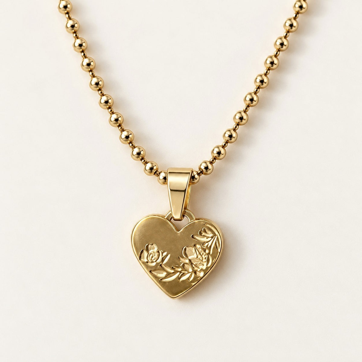 Engraved Heart Necklace on a cream background