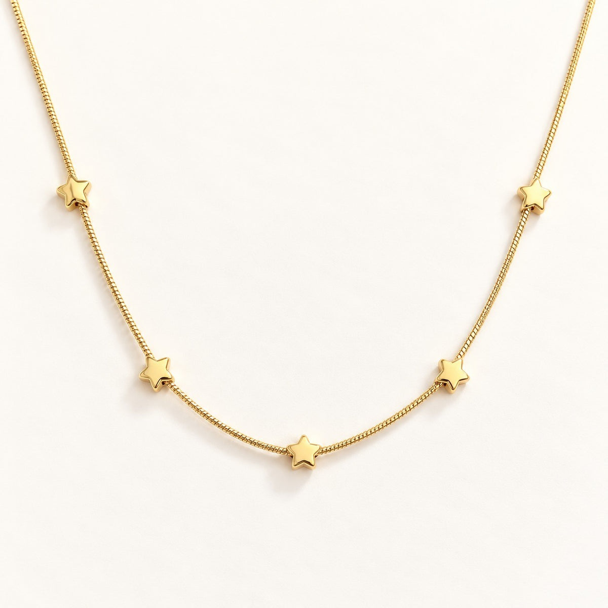 Golden Star Station Necklace on a cream background